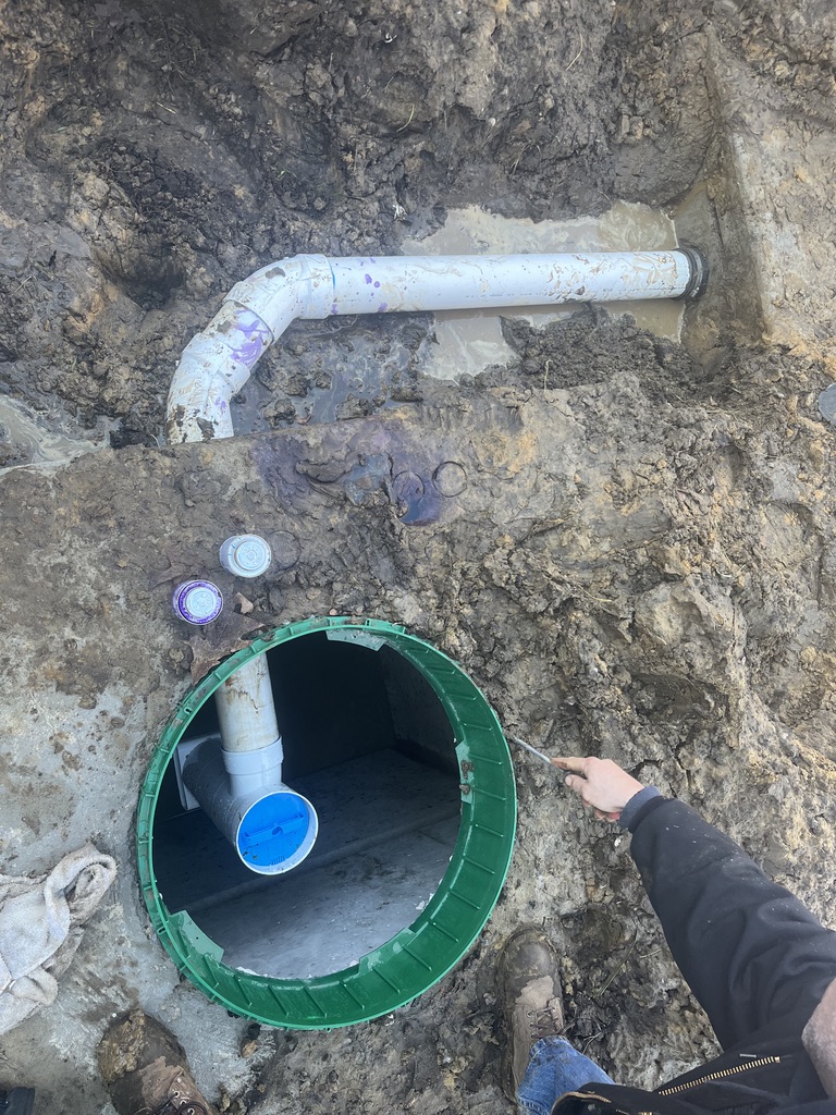 Close-up of septic system piping and access riser during installation